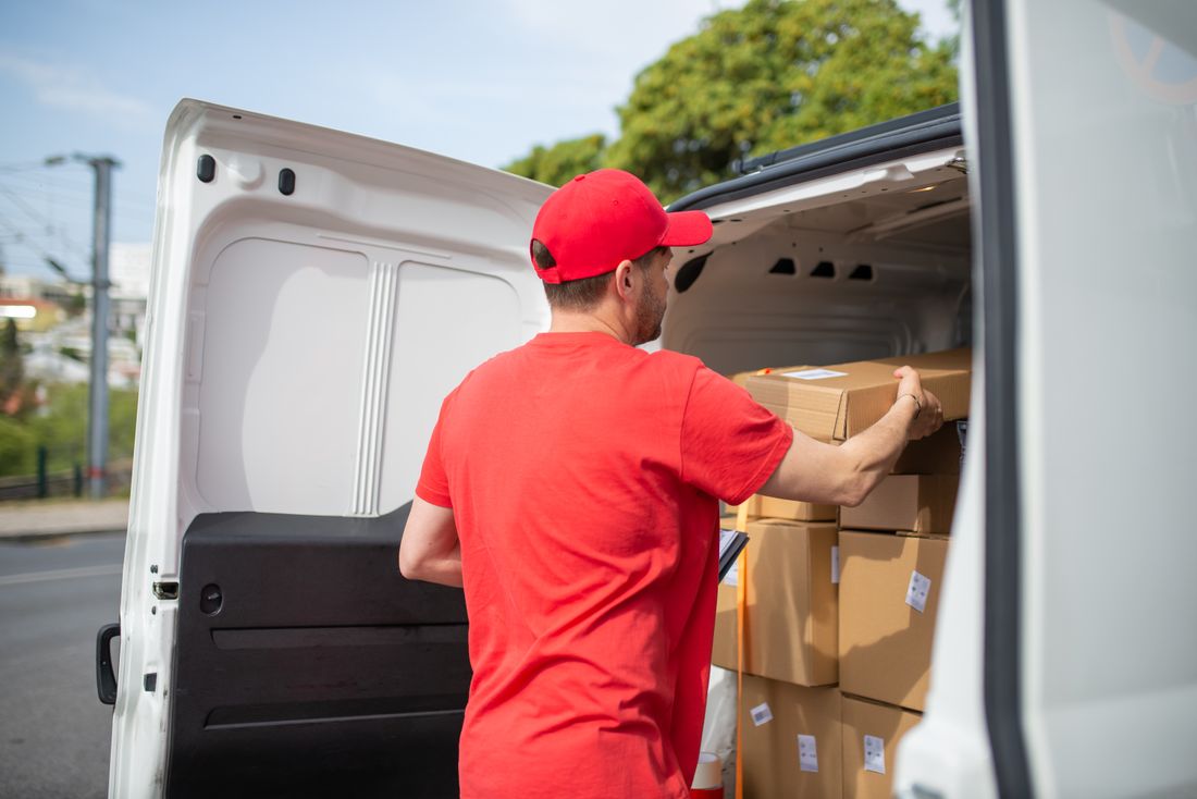 Courier loading parcels into a delivery van
